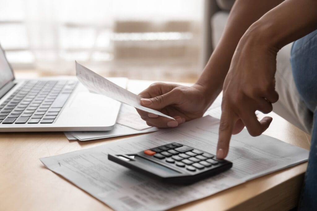 Person using calculator to solve Debt challenges