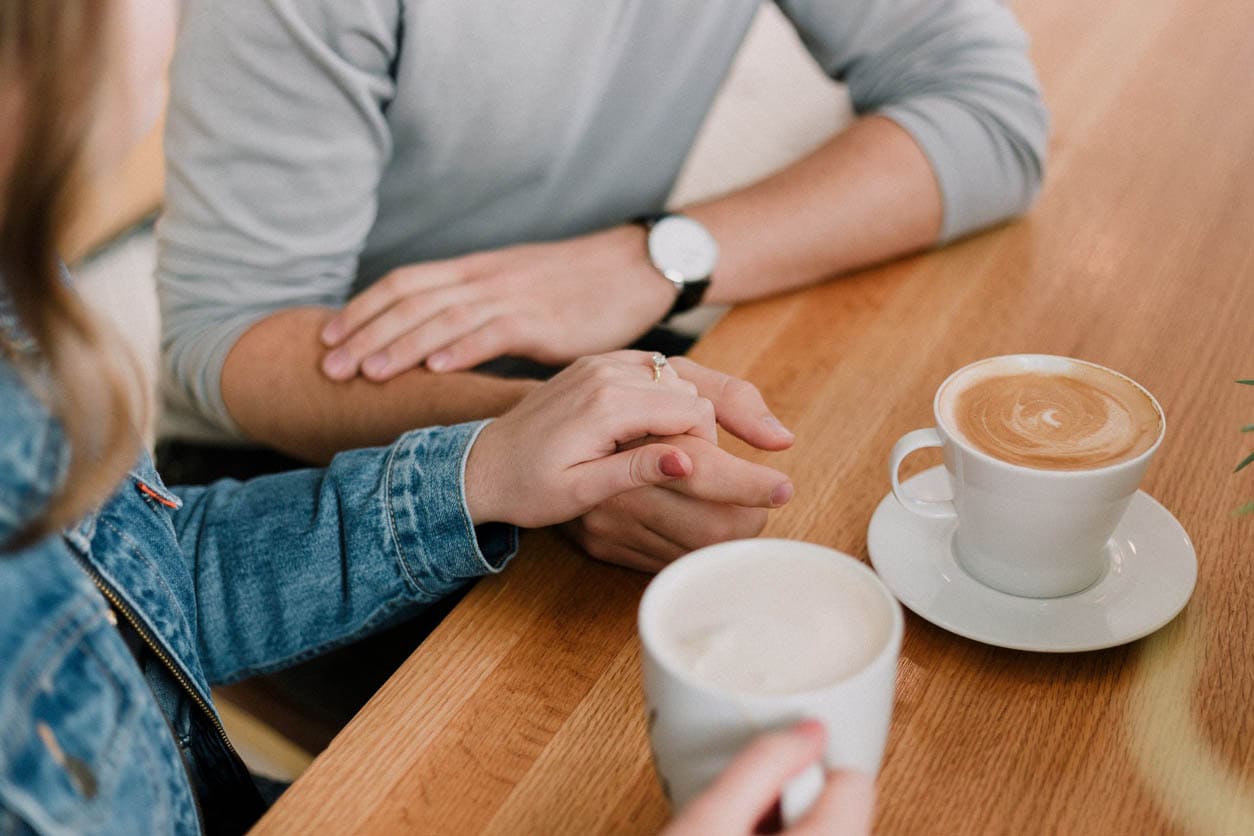 Couple talking about debt over coffee