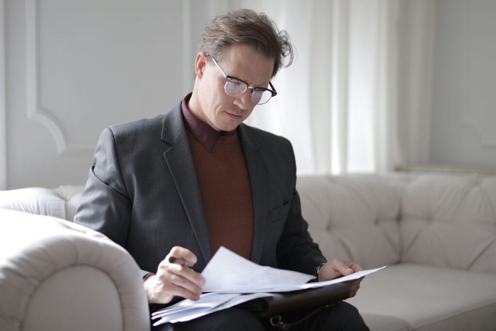man looking over papers for a plan for paying off his debt
