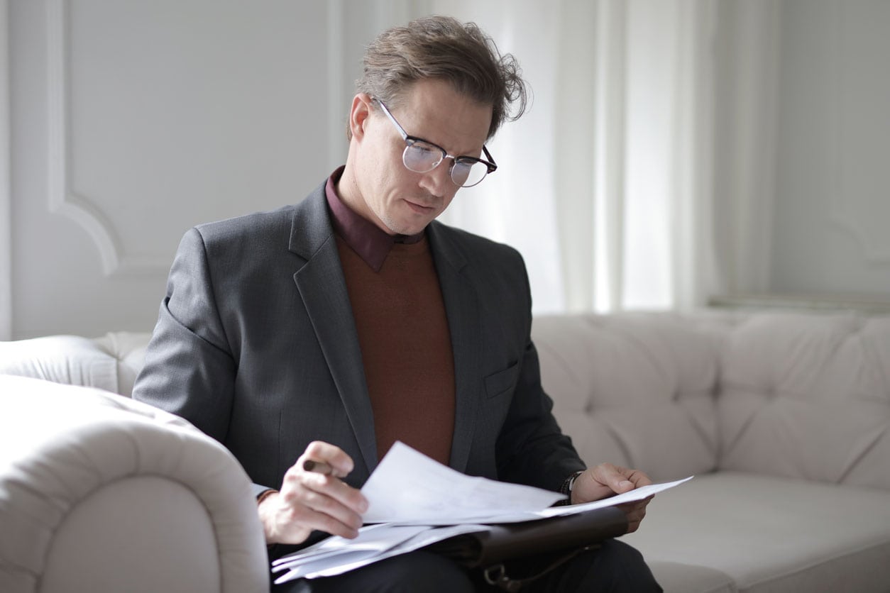man looking over papers for a plan for paying off his debt