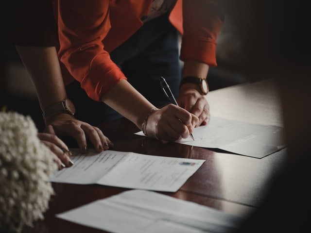 two people signing new debt restructuring paperwork